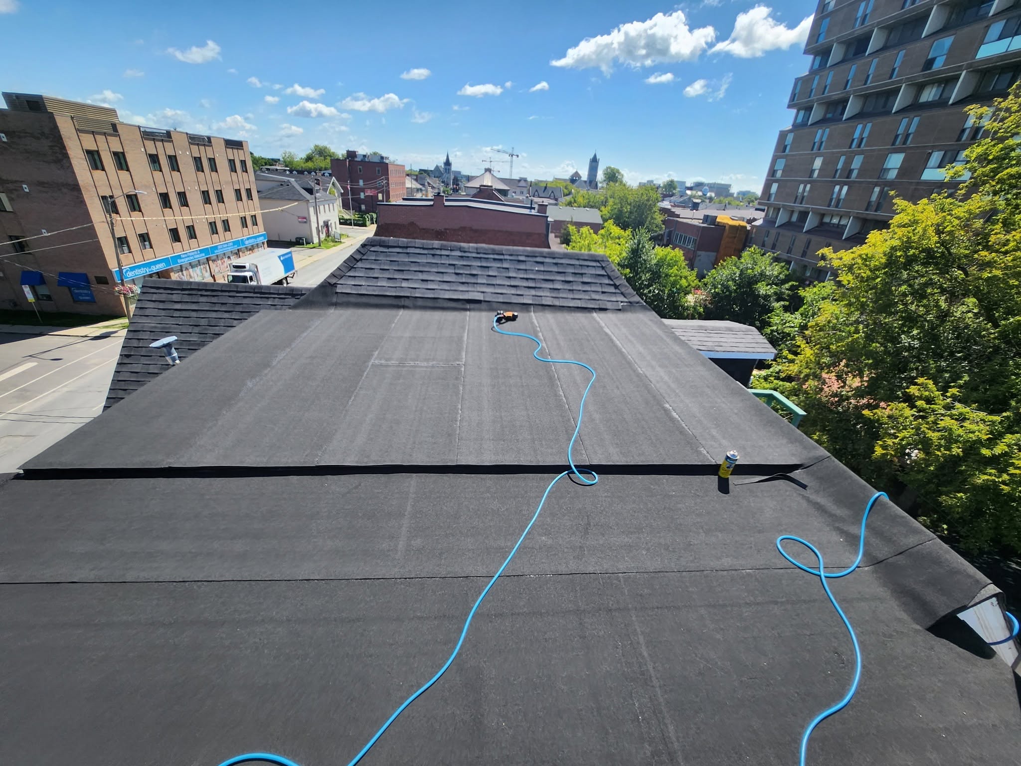 A.A. Roofing torch-on flat roof job on a downtown Kingston building, church spires visible in the skyline