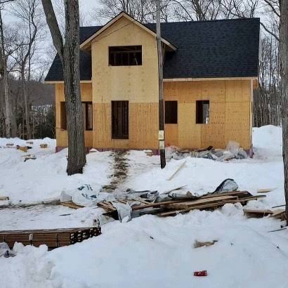 New-build home framed and roofed, deep snow on the ground